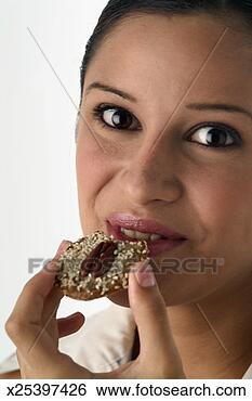Stock Photo - smiling young 
woman eating cookie, 
close-up. fotosearch 
- search stock 
photos, pictures, 
images, and photo 
clipart