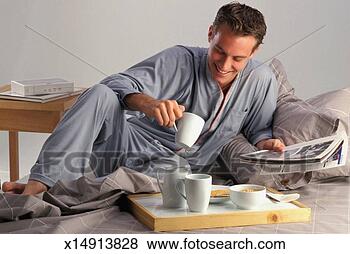 Stock Photo - mid adult man 
holding magazine 
and mug, smiling. 
fotosearch - search 
stock photos, 
pictures, images, 
and photo clipart
