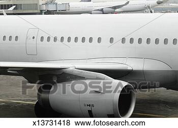 Stock Photo - midsection of 
jet airplane in 
front of a full 
length airplane 
at. fotosearch 
- search stock 
photos, pictures, 
images, and photo 
clipart