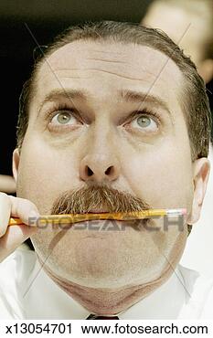 Stock Photography - close-up of a mature man biting a pencil. fotosearch - search stock photos, pictures, wall murals, images, and photo clipart