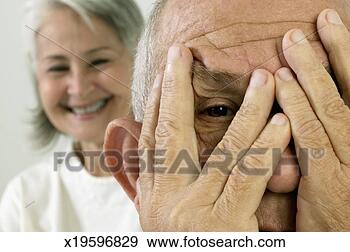 Stock Photograph - senior man with 
hand in front 
of face and fingers 
spread apart, 
 and. fotosearch 
- search stock 
photos, pictures, 
images, and photo 
clipart