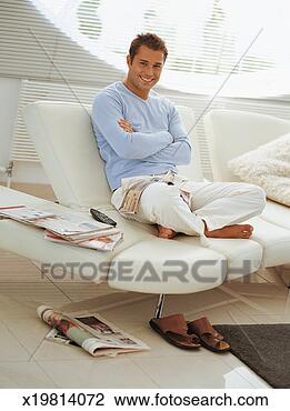 Stock Photo - portrait of a 
barefoot,  young 
man sitting cross 
legged on a sofa. 
fotosearch - search 
stock photos, 
pictures, images, 
and photo clipart