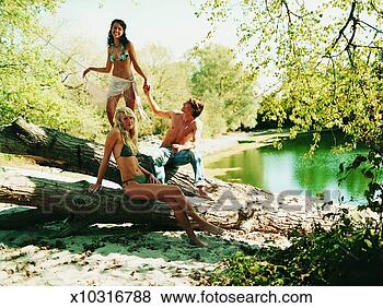 Stock Photo - young woman balancing 
on a log at the 
edge of a lake 
holding hands. 
fotosearch - search 
stock photos, 
pictures, images, 
and photo clipart