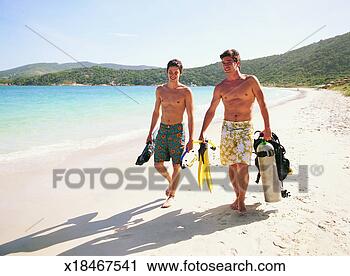 Stock Photography - two smiling, young 
men walking on 
a beach with scuba 
diving equipment. 
fotosearch - search 
stock photos, 
pictures, images, 
and photo clipart