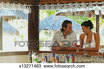 Stock Photo - man sitting at 
a bar holding 
a cocktail chatting 
to a shy woman. 
fotosearch - search 
stock photos, 
pictures, images, 
and photo clipart