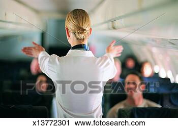 Stock Photography - rear view of air 
stewardess explaining 
aeroplane safety 
to passengers. 
fotosearch - search 
stock photos, 
pictures, images, 
and photo clipart