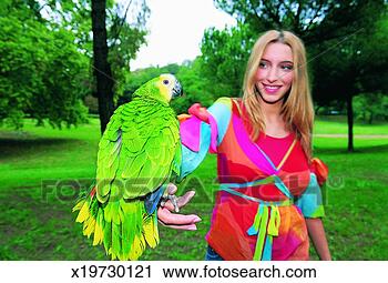 Stock Photography - portrait of a 
woman holding 
a parrot in the 
park. fotosearch 
- search stock 
photos, pictures, 
images, and photo 
clipart