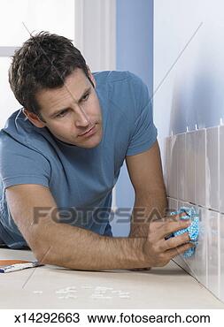 Stock Photo - man rubbing with 
a cloth on a tiled 
wall. fotosearch 
- search stock 
photos, pictures, 
images, and photo 
clipart