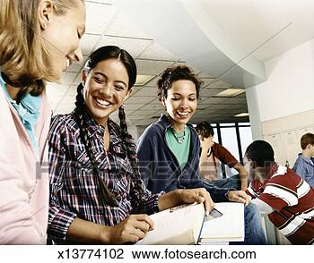 Stock Photo - three female students 
sat on a row of 
lockers looking 
at a book. fotosearch 
- search stock 
photos, pictures, 
images, and photo 
clipart