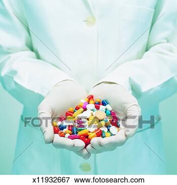 Picture - mid section view 
of an adult in 
a lab coat holding 
a pile of pills. 
fotosearch - search 
stock photos, 
pictures, images, 
and photo clipart