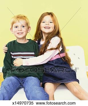 Stock Image - portrait of a 
smiling boy and 
girl sitting on 
a chair,  girl 
with her. fotosearch 
- search stock 
photos, pictures, 
images, and photo 
clipart