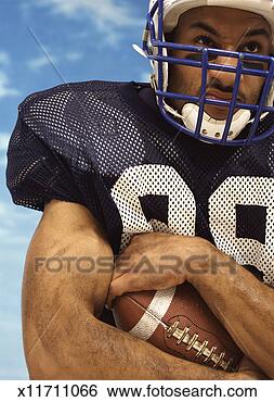 Stock Photo - determined american 
football player 
holding an american 
football. fotosearch 
- search stock 
photos, pictures, 
images, and photo 
clipart