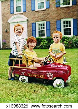 Stock Image - boy with red hair 
sitting in a toy 
car with his twin 
brothers. fotosearch 
- search stock 
photos, pictures, 
images, and photo 
clipart