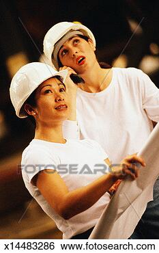 Stock Photo - two women looking 
upwards; one woman 
talking on cellular 
phone. fotosearch 
- search stock 
photos, pictures, 
images, and photo 
clipart