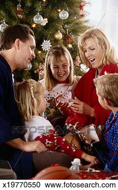 Stock Photography - family opening 
christmas present 
on christmas. 
fotosearch - search 
stock photos, 
pictures, images, 
and photo clipart