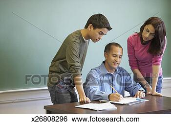 Stock Photo - teenage boy and 
a teenage girl 
standing beside 
a male lecturer 
in a. fotosearch 
- search stock 
photos, pictures, 
images, and photo 
clipart