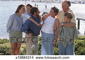 Stock Photo - multigenerational 
family with children 
standing by seashore. 
fotosearch - search 
stock photos, 
pictures, images, 
and photo clipart