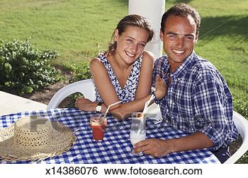 Stock Photo - young couple sitting 
side by side at 
table in garden, 
 with drinks. 
fotosearch - search 
stock photos, 
pictures, images, 
and photo clipart