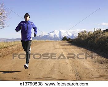 Stock Photo - mid adult man 
jogging on dirt 
road. fotosearch 
- search stock 
photos, pictures, 
images, and photo 
clipart