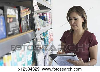 Stock Photograph - mid adult woman 
taking inventory 
in a paint store. 
fotosearch - search 
stock photos, 
pictures, images, 
and photo clipart