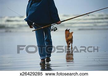 Stock Image - man walking with 
dog carrying rod 
and reel. fotosearch 
- search stock 
photos, pictures, 
images, and photo 
clipart