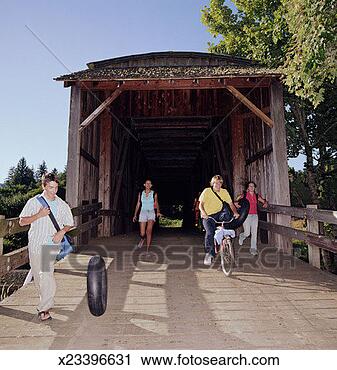 Stock Photography - group of teenagers 
(14-16) walking 
across covered 
bridge, summer. 
fotosearch - search 
stock photos, 
pictures, images, 
and photo clipart
