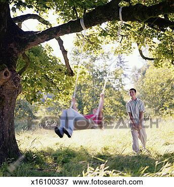 Picture - teenage boy pushing 
teenage girl (14-16) 
on swing (blurred 
motion). fotosearch 
- search stock 
photos, pictures, 
images, and photo 
clipart