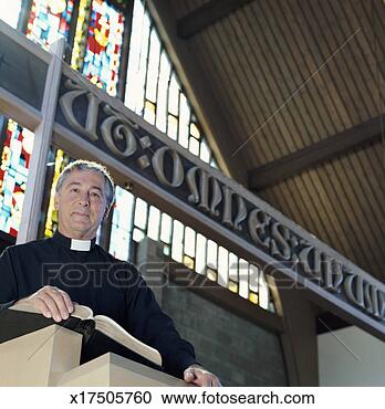 Stock Photography - priest standing 
at a pulpit with 
an open bible, 
 near a sign written. 
fotosearch - search 
stock photos, 
pictures, images, 
and photo clipart