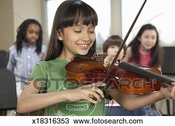 Stock Photo - girl (6-12) playing 
violin in music 
class (focus on 
girl). fotosearch 
- search stock 
photos, pictures, 
images, and photo 
clipart