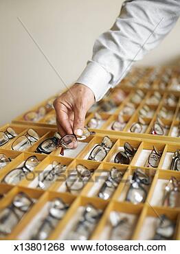 Stock Photo - man selecting 
a pair of eyeglasses 
from display case 
in shop. fotosearch 
- search stock 
photos, pictures, 
images, and photo 
clipart