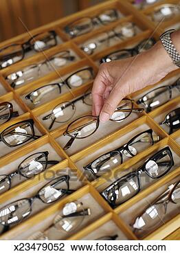 Stock Photo - man selecting 
a pair of eyeglasses 
from display case 
in shop. fotosearch 
- search stock 
photos, pictures, 
images, and photo 
clipart