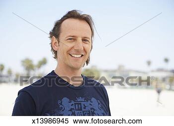 Stock Image - mid adult man 
on beach, smiling, 
portrait, head 
and shoulders. 
fotosearch - search 
stock photos, 
pictures, images, 
and photo clipart