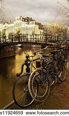 Stock Photograph - bicycles leaning 
by the railing 
of a canal, amsterdam. 
fotosearch - search 
stock photos, 
pictures, images, 
and photo clipart