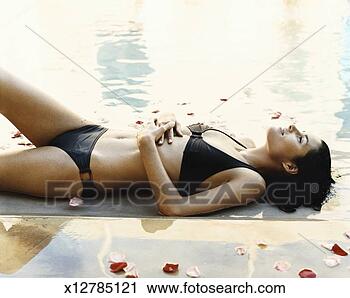 Stock Photography - serene looking 
woman lying amongst 
petals by a poolside. 
fotosearch - search 
stock photos, 
pictures, images, 
and photo clipart