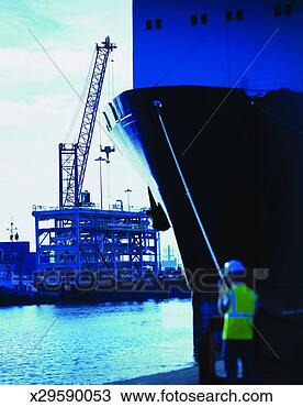 Stock Photo - man stands by 
the bow of a ship 
watching oil rig 
construction in. 
fotosearch - search 
stock photos, 
pictures, images, 
and photo clipart