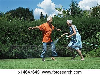 Stock Photo - elderly woman 
chasing an elderly 
man with a hosepipe. 
fotosearch - search 
stock photos, 
pictures, images, 
and photo clipart