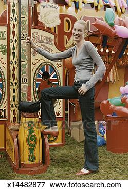 Picture - woman posing at 
an old fashioned 
fairground strength 
game,  holding 
a. fotosearch 
- search stock 
photos, pictures, 
images, and photo 
clipart
