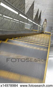 Stock Photo - businesswoman 
stands at the 
bottom of an escalator 
phoning on her. 
fotosearch - search 
stock photos, 
pictures, images, 
and photo clipart