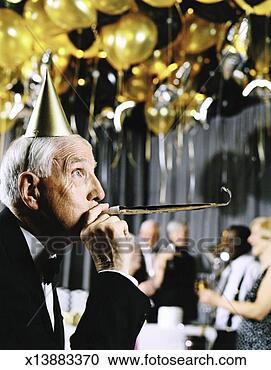 Stock Photography - well dressed senior 
man at a party 
wearing a party 
hat and using 
a. fotosearch 
- search stock 
photos, pictures, 
images, and photo 
clipart