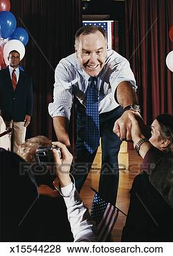 Stock Photo - american politician 
reaching out to 
shake hands with 
supporters at 
a. fotosearch 
- search stock 
photos, pictures, 
images, and photo 
clipart