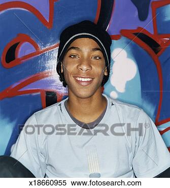 Stock Image - portrait of a 
teenage boy wearing 
a beanie hat, 
 sitting by a 
wall. fotosearch 
- search stock 
photos, pictures, 
images, and photo 
clipart