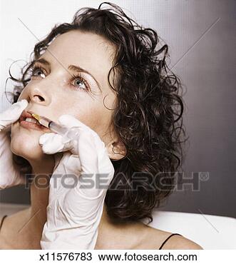 Stock Photo - young woman recieving 
a collagen injection 
to her upper lip 
as part. fotosearch 
- search stock 
photos, pictures, 
images, and photo 
clipart