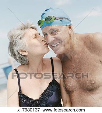 Picture - elderly woman 
kisses an elderly 
man wearing a 
swimming cap and. 
fotosearch - search 
stock photos, 
pictures, images, 
and photo clipart