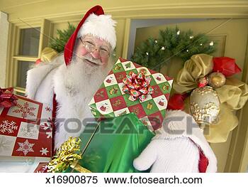 Stock Image - father christmas 
standing in front 
of a front door 
holding christmas. 
fotosearch - search 
stock photos, 
pictures, images, 
and photo clipart