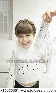 Stock Photography - young girl holding 
a snowflake christmas 
decoration. fotosearch 
- search stock 
photos, pictures, 
images, and photo 
clipart