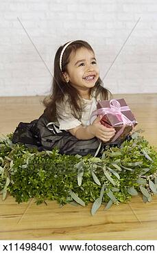 Stock Photography - young girl sitting 
in the centre 
of a christmas 
garland decoration. 
fotosearch - search 
stock photos, 
pictures, images, 
and photo clipart