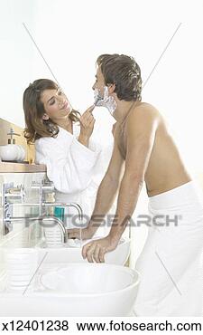 Stock Photo - couple stand by 
a bathroom sink, 
the woman shaving 
the man's chin. 
fotosearch - search 
stock photos, 
pictures, images, 
and photo clipart