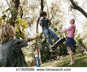 Stock Photo - four young boys 
and girls in a 
garden,  one of 
the boys standing 
on a. fotosearch 
- search stock 
photos, pictures, 
images, and photo 
clipart