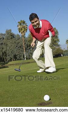 Stock Photography - man playing golf 
on a golf course 
looking at a golf 
ball almost enter. 
fotosearch - search 
stock photos, 
pictures, images, 
and photo clipart