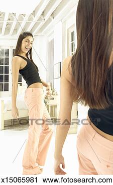 Stock Photography - surprised young 
woman looking 
in the mirror, 
 looking at her 
large. fotosearch 
- search stock 
photos, pictures, 
images, and photo 
clipart
